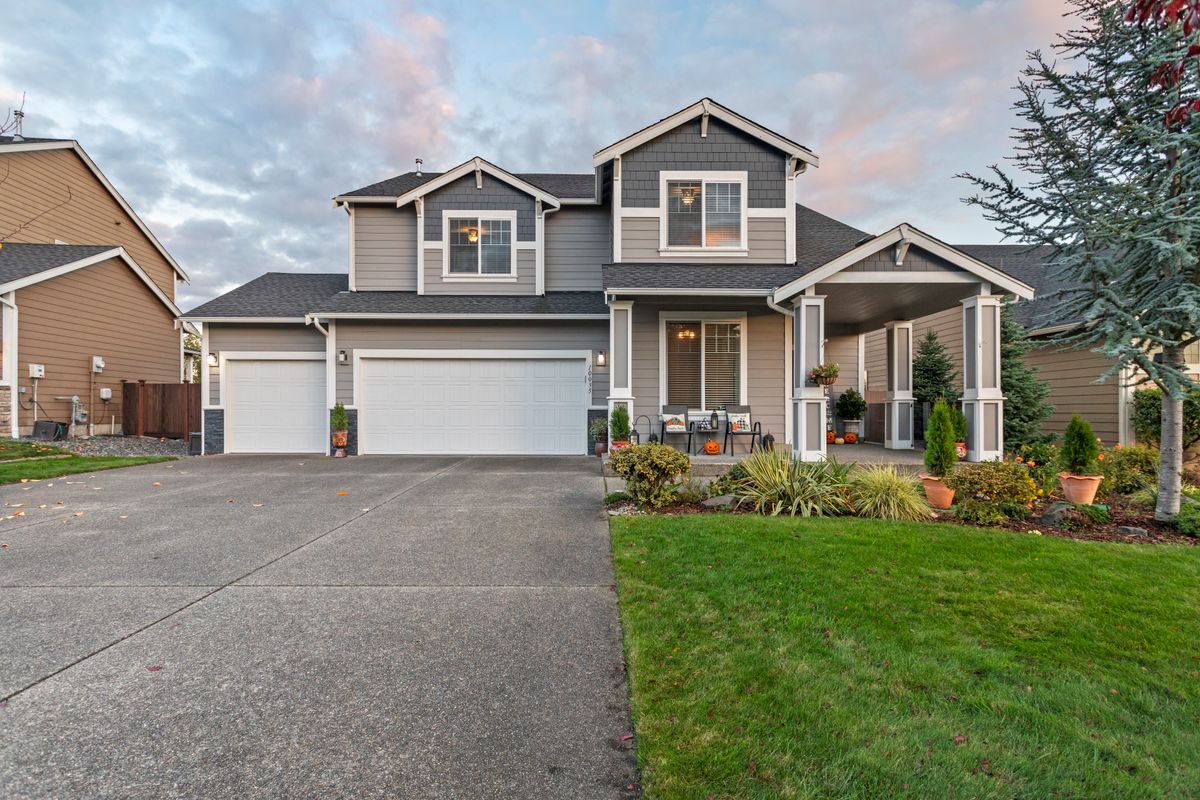 Home with a wide concrete driveway and front walkway in the evening